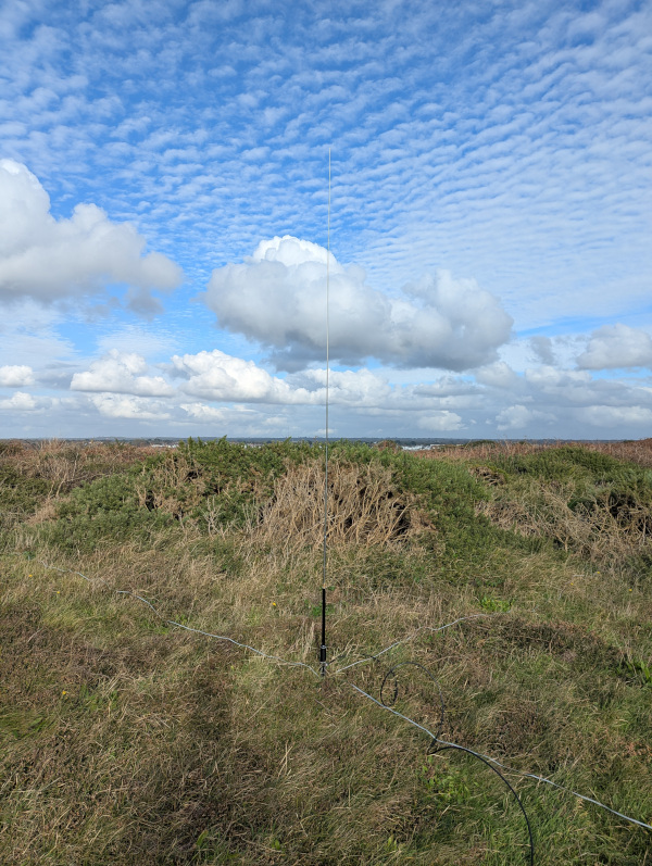 JPC-12 antenna set up under a sky with a dense wavy cloud pattern