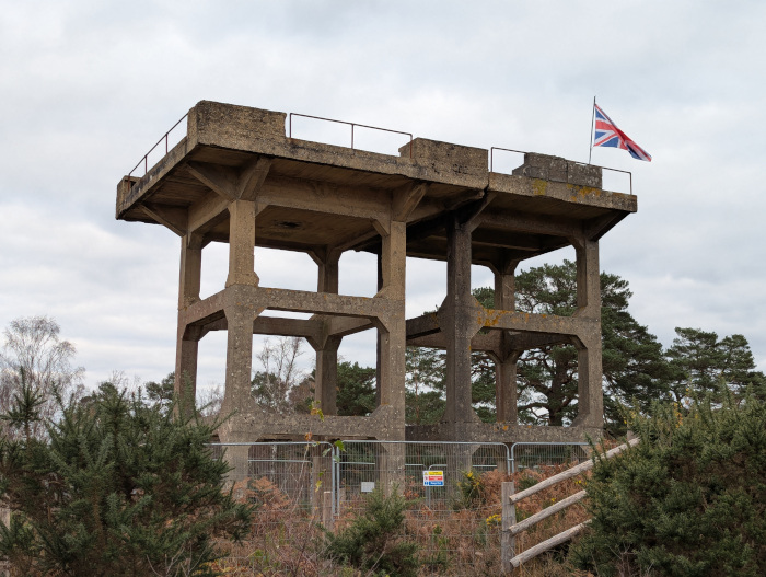 A tall and empty concrete structure, with a British flag flying on top