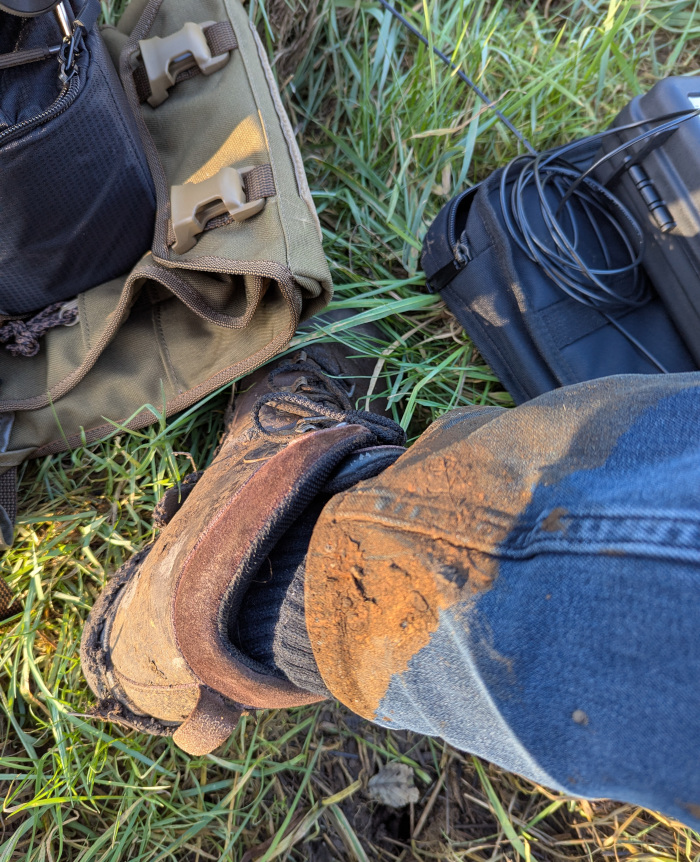 Boots and jeans caked in drying brown mud