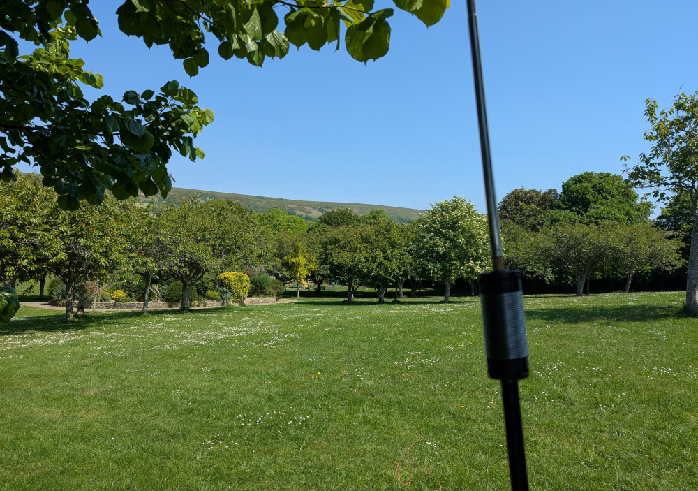 Coil of a JPC-12 antenna in the foreground, with grass and trees in the background