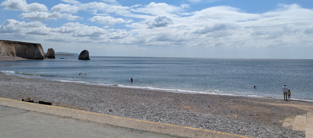 A stony beach with blue sea and sunny blue sky