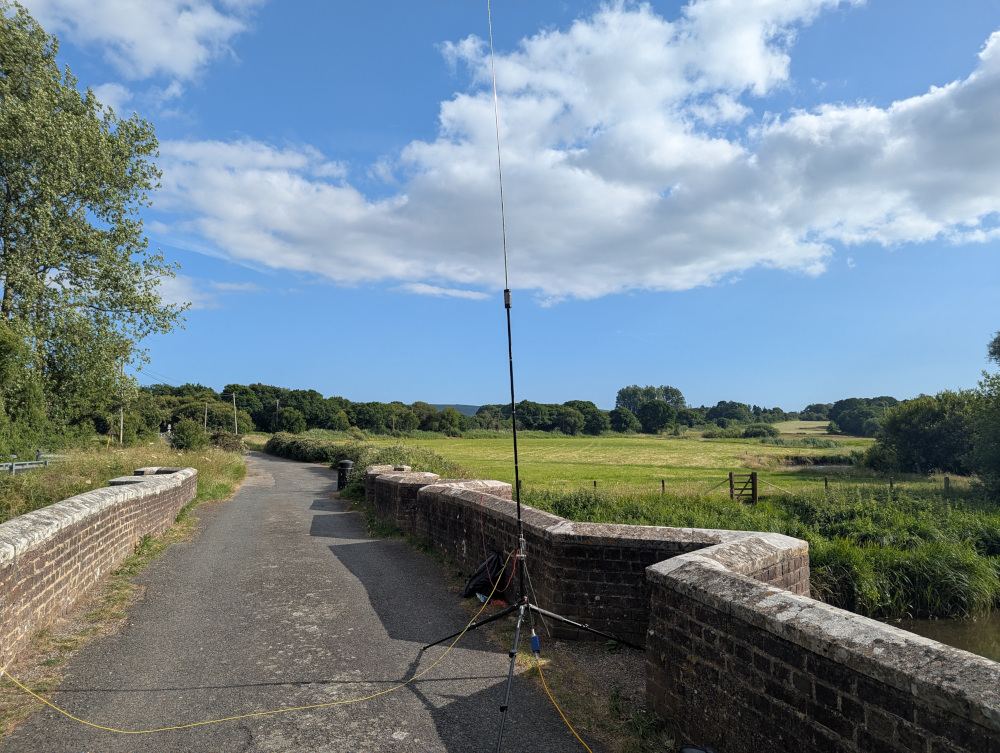 A JPC-12 vertical antenna on a tripod, with ground radials draping across the bridge