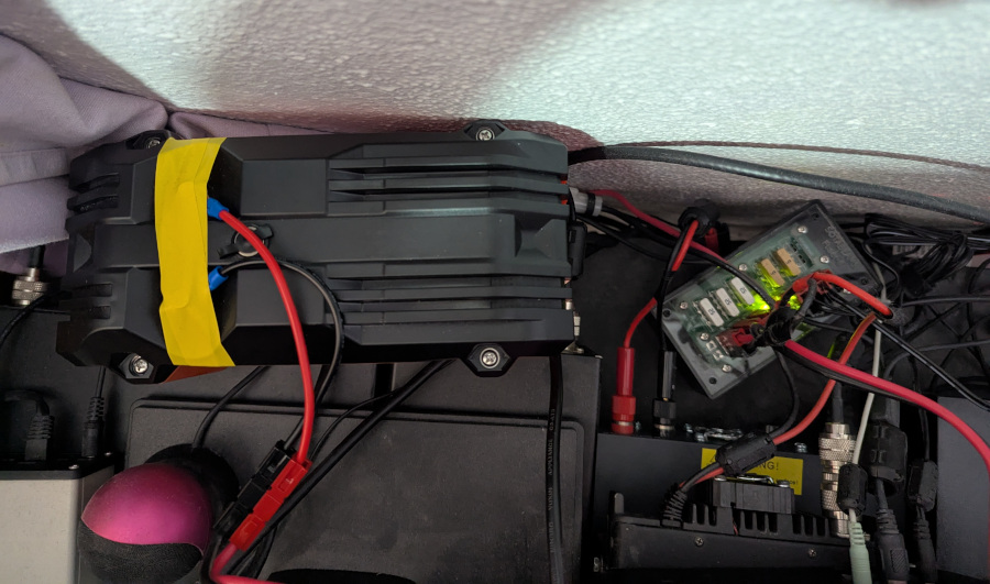 Photo behind my desk showing a big battery plugged into a PowerPole distribution box