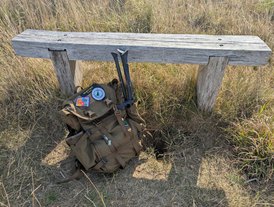 A small wooden bench with my bag resting against it