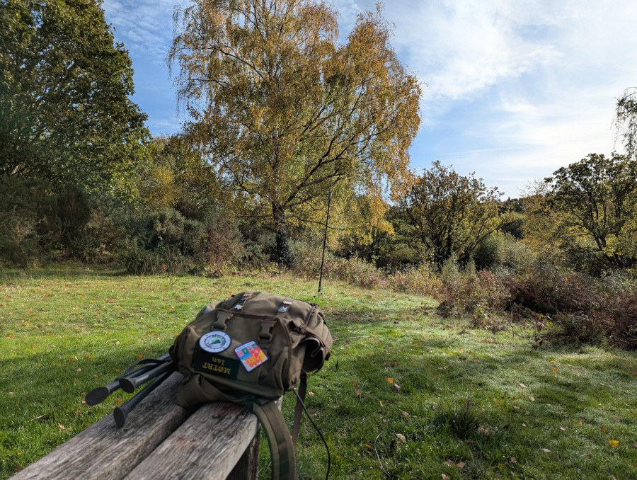 Antenna and heathland in the background, rucksack in the foreground on a simple wooden bench