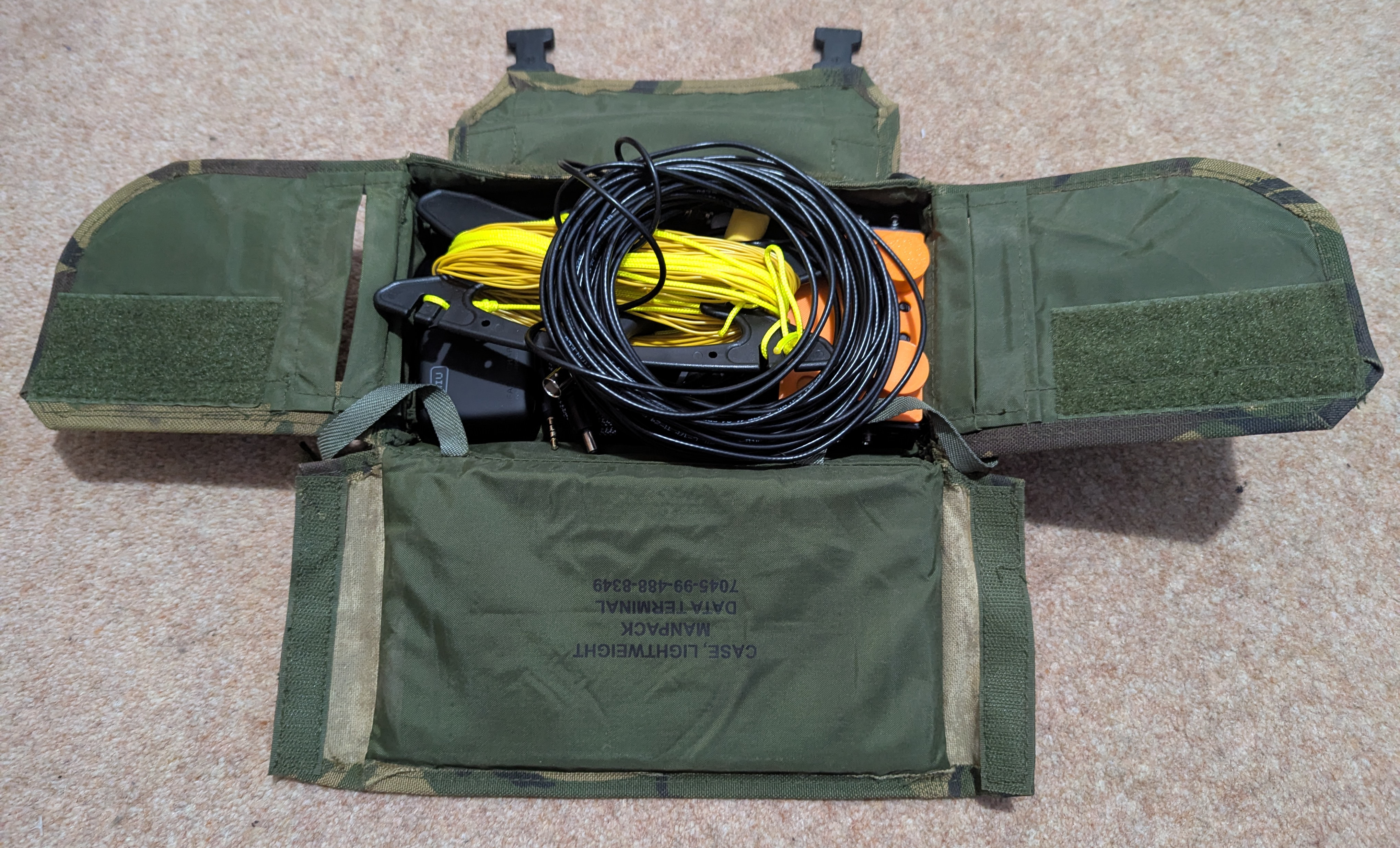 Military camo pouch with flapped out sides, and all the radio kit inside