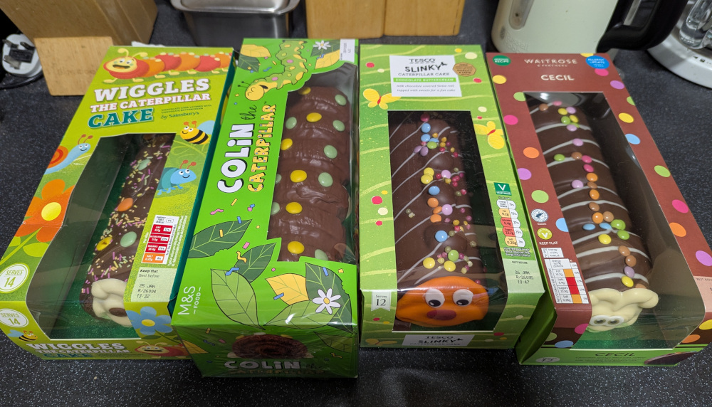 Four caterpillar cakes in boxes