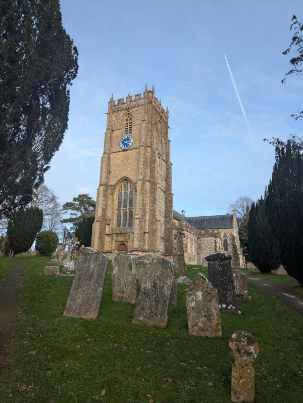 Church tower and building surrounded by gravestones
