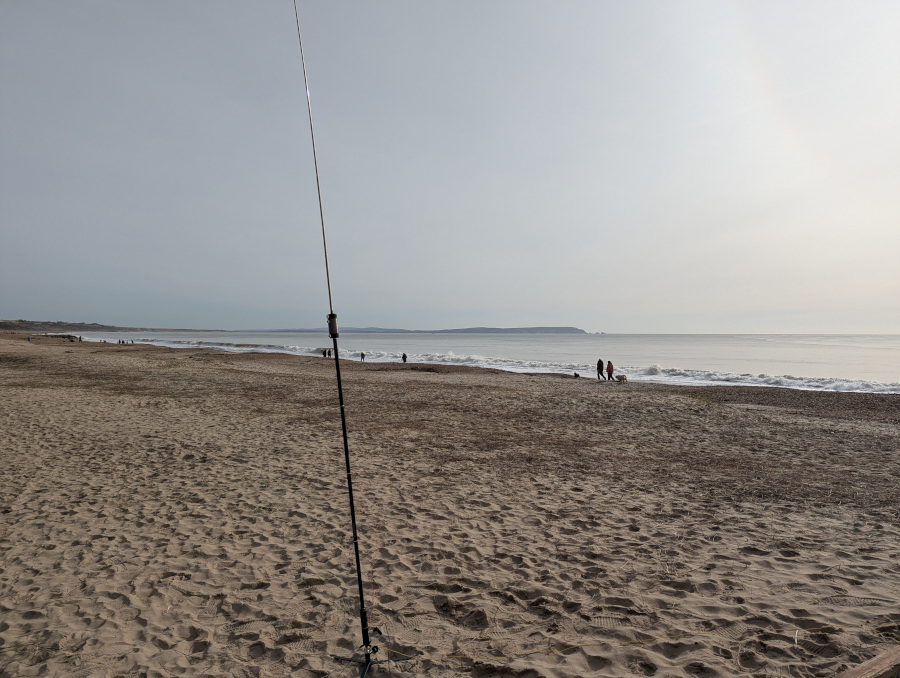 Vertical antenna on the beach, Isle of Wight in the background