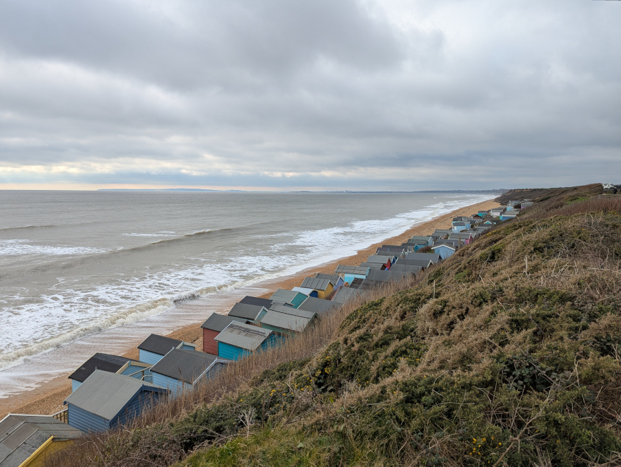 Seascape with the tops of beach huts in the foreground