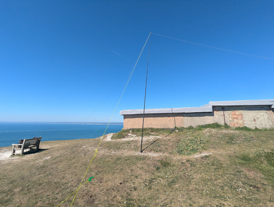 Inverted-V dipole antenna set up next to a bench and a concrete structure
