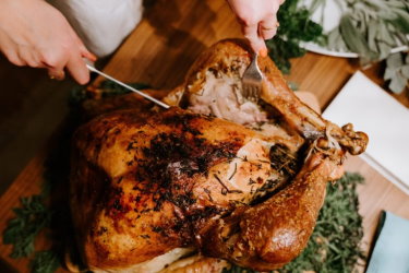 A knife cutting into a roast chicken