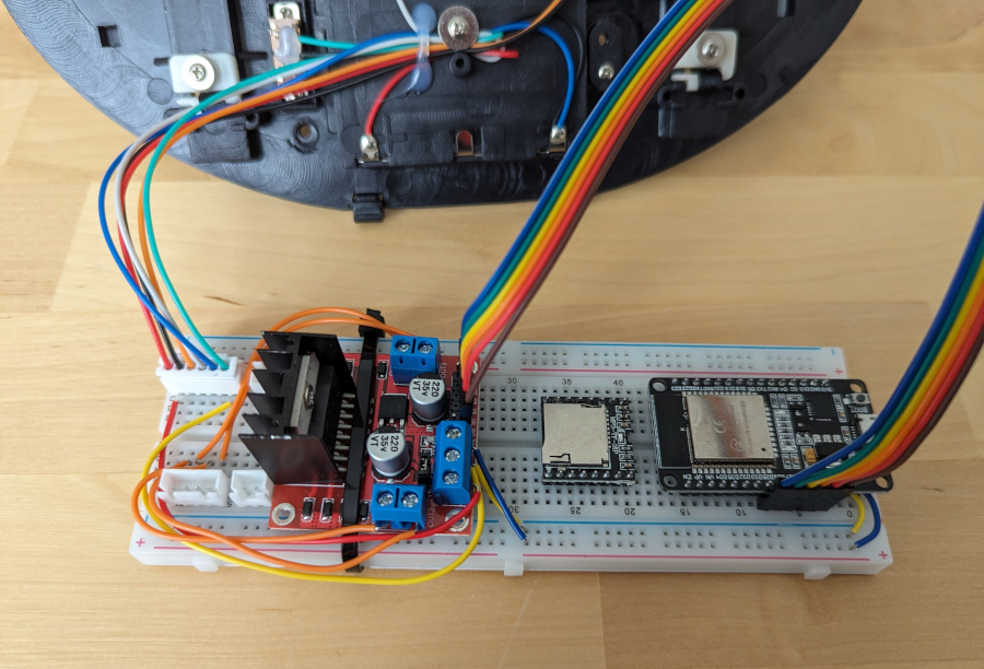 Rear shell of Billy Bass with breadboard in front. The breadboard has a motor driver and microprocessor board, and a mess of wiring.