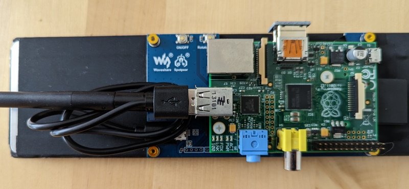 The Pi mounted to the screen, with a USB cable and WiFi dongle